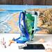 The side of a blue, green and white leaf print water bottle bag is displayed while it holds a 40 oz Stanley Quencher.

